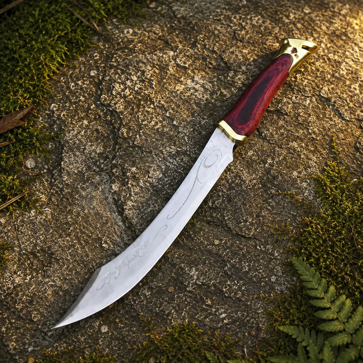 Elven knife of Aragorn prop replica close-up of deep crimson pakkawood grip with rich red-black wood grain texture gold brass crossguard and ornate gold brass pommel cap with cutout notch design and gemstone accent on mossy rock – LOTR Aragorn fan gift