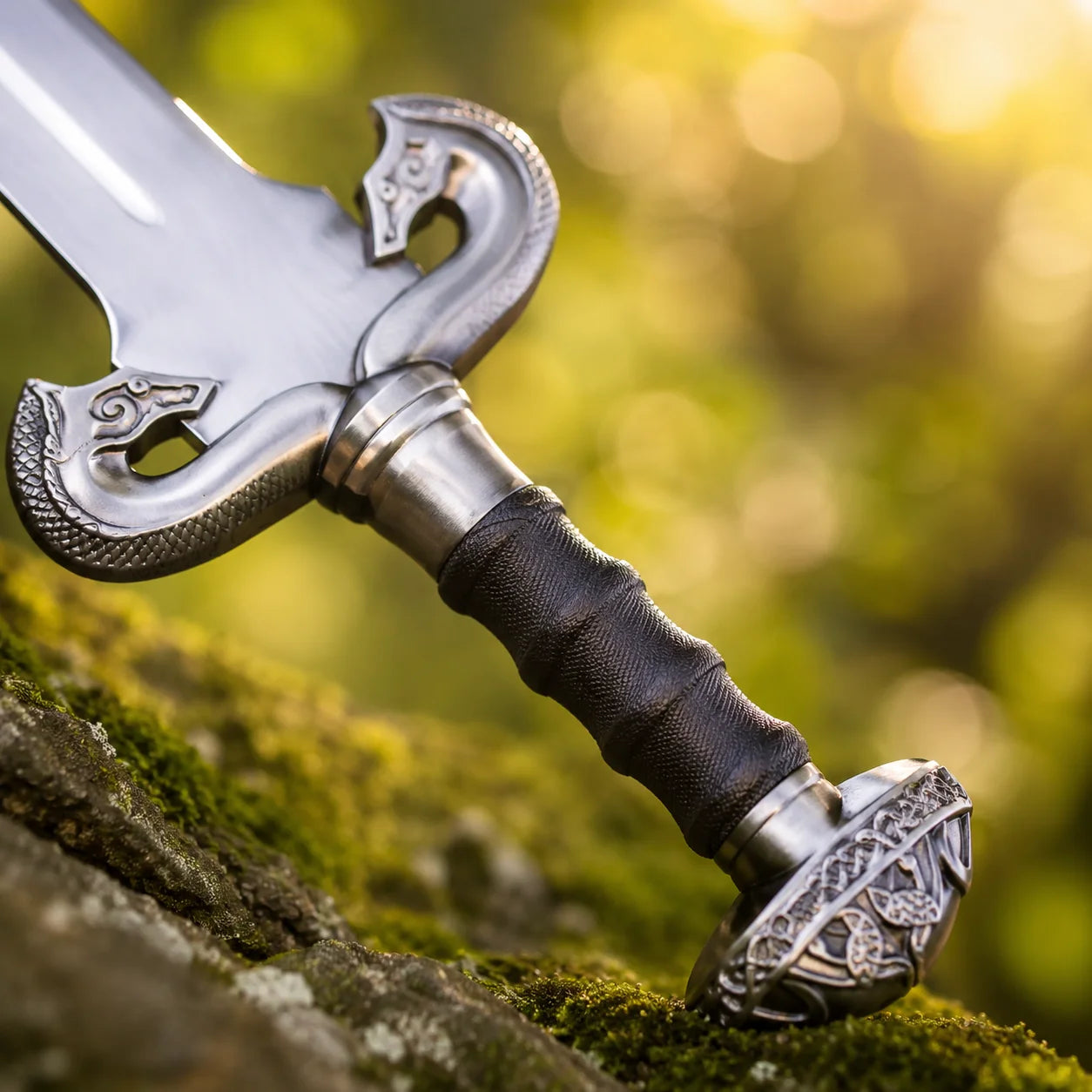 Éowyn sword prop replica blade tip close-up in golden bokeh showing polished silver single fuller profile and clean taper – LOTR Shieldmaiden of Rohan display collectible