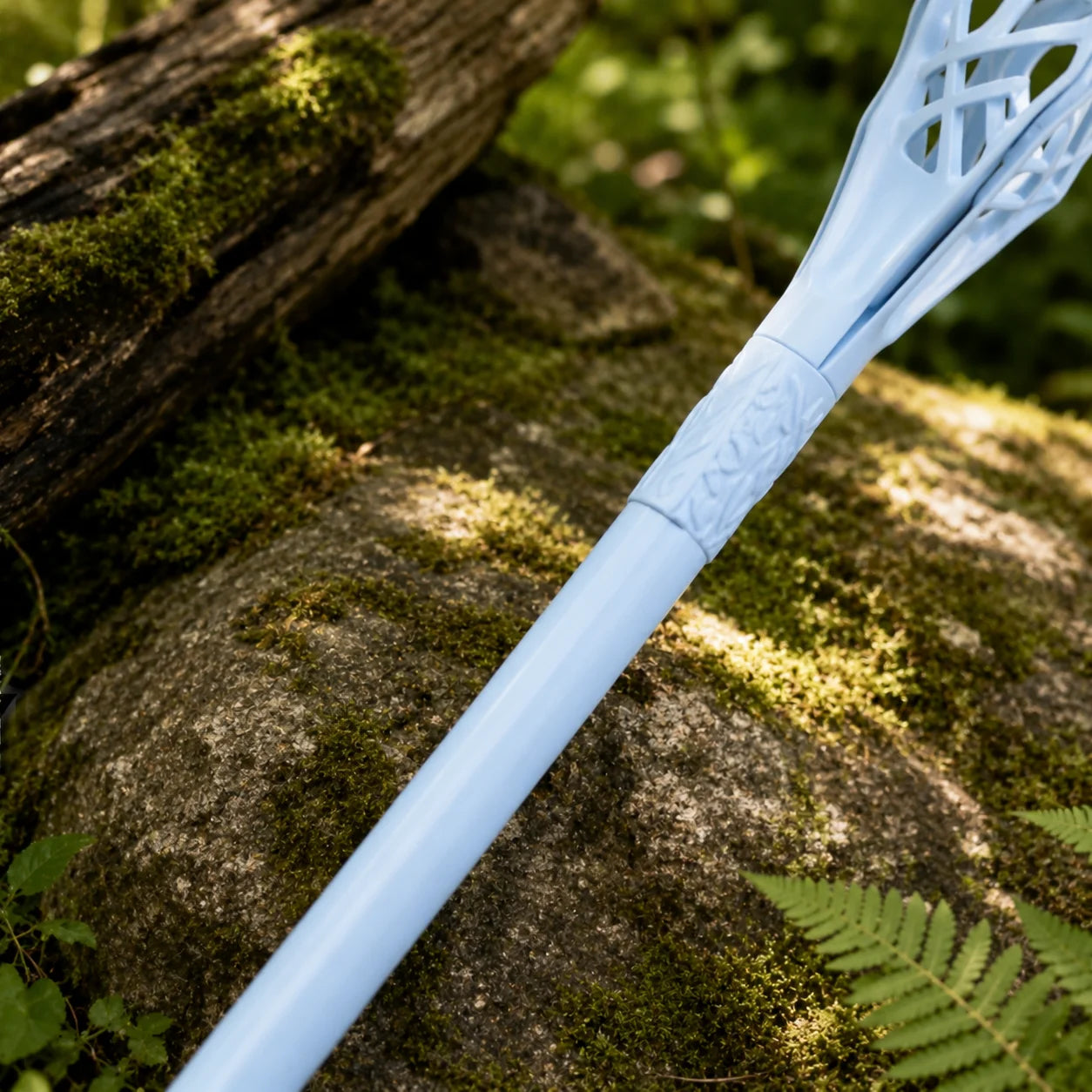 Gandalf the White staff prop replica held aloft in gloved hand in sunlit forest showing full pale blue-white stainless steel shaft with ornate lattice cage topper and pointed tip – LOTR cosplay prop
