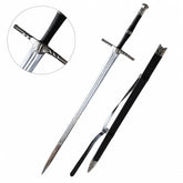 Geralt of Rivia steel sword prop replica full length on mossy rock with free black leather scabbard showing polished silver blade triple fuller grooves ornate silver crossguard twisted quillons black cord grip silver ring spacers and silver faceted pommel – Witcher display collectible