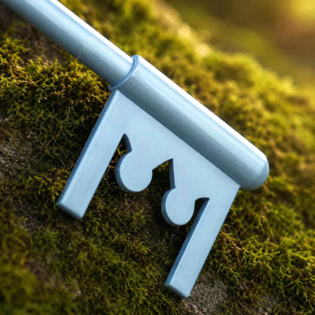Sora Kingdom Key Keyblade prop replica side profile view in forest setting – Kingdom Hearts display collectible