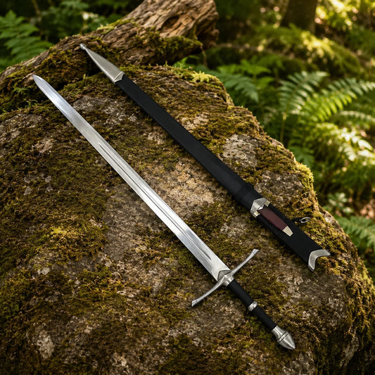 Aragorn Strider ranger sword prop replica full length on mossy fallen log in sunlit forest showing double fuller blade straight crossguard and bullet-shaped silver pommel – LOTR collectible