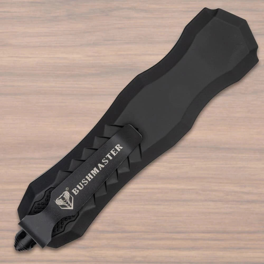 Bushmaster Diamondback OTF Knife collector display piece with black angular handle, silver-tone accent detail, textured grip panels, branded clip, and compact showcase presentation
