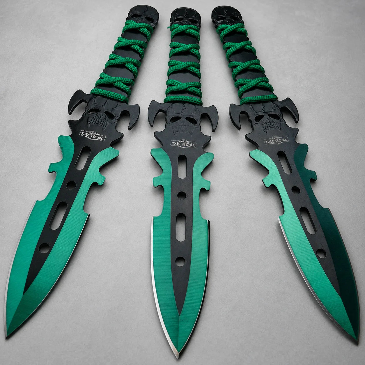 Three teal fantasy dagger-style display prop collectibles with skull detailing, black centres and green wrapped handles