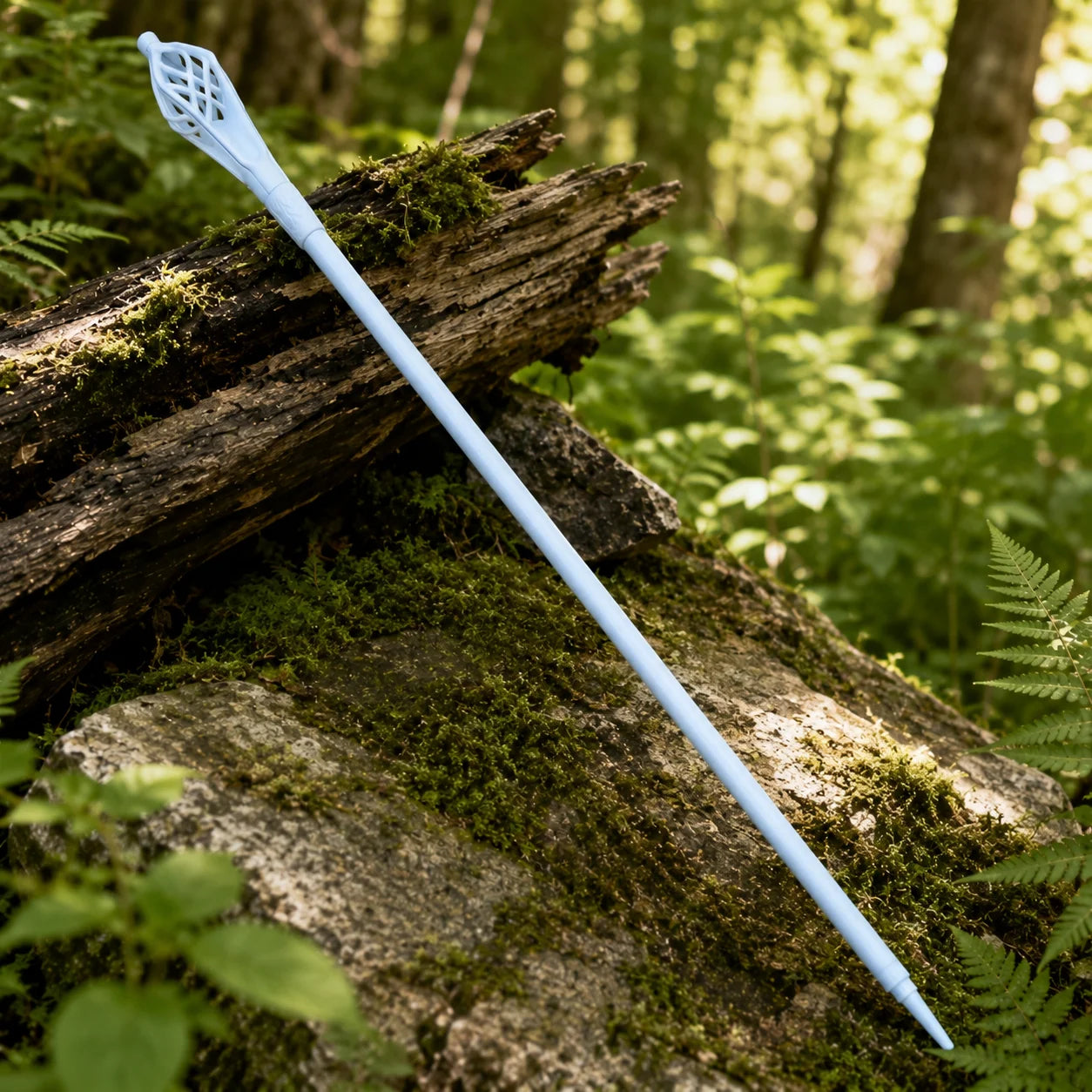 Gandalf the White staff prop replica close-up of ornate lattice cage-style topper with interlocking curved ribs leaf cutout pattern and embossed rune-style collar engravings on mossy log – LOTR fan gift