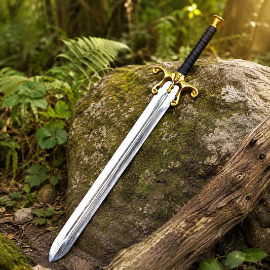 He-Man 1987 Movie Sword prop replica close-up macro of ornate gold brass skull cross-guard with decorative scrollwork curls on both quillons and black leather-wrapped handle with tight horizontal wrap on mossy rock in sunlit green forest bokeh – He-Man Masters of the Universe 1987 film display collectible