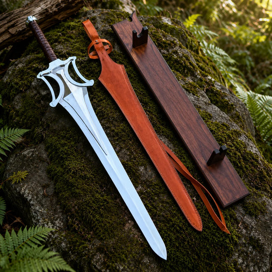 He-Man Power Sword prop replica dramatic hero display leaning on mossy rock in sunlit green forest showing full silver chrome mirror-polish display finish blade with double fuller groove tapered display point open-work cross-guard four curved cutout arches and dark brown leather-wrapped handle – Masters of the Universe fantasy collectible
