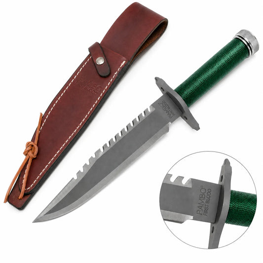 Rambo First Blood Standard Edition knife prop replica full hero view on mossy rock with brown leather RAMBO FIRST BLOOD embossed sheath snap button closure and leather tie lace showing grey silver satin display finish blade serrated saw-tooth spine green paracord-wrapped hollow handle and knurled silver pommel cap – movie display collectible