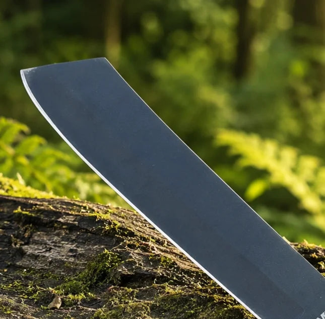 Rambo IV Machete prop replica wide display view on mossy rock showing full wide black matte display finish cleaver-style blade profile with RAMBO engraving black leather-wrapped handle finger-notch guard black steel pommel cap and black leather lanyard in sunlit green forest – Rambo IV cosplay prop fan gift