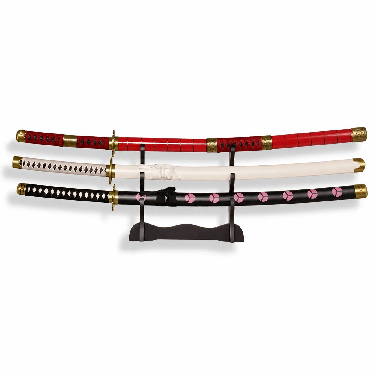 Roronoa Zoro One Piece three sword set replica featuring Sandai Kitetsu (red scabbard), Wado Ichimonji (white scabbard), and Enma (black scabbard with pink floral motifs) displayed on a wooden katana stand