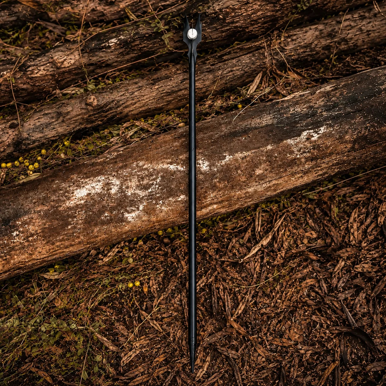 Saruman staff prop replica full length diagonal view on forest logs – LOTR wizard collectible