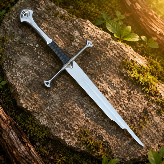 Shards of Narsil prop replica full length resting on mossy forest rock in golden sunlight showing polished silver blade – LOTR Aragorn collectible