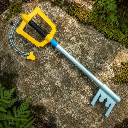 Kingdom Hearts Sora Keyblade prop replica lying on mossy forest ground – game collectible display piece