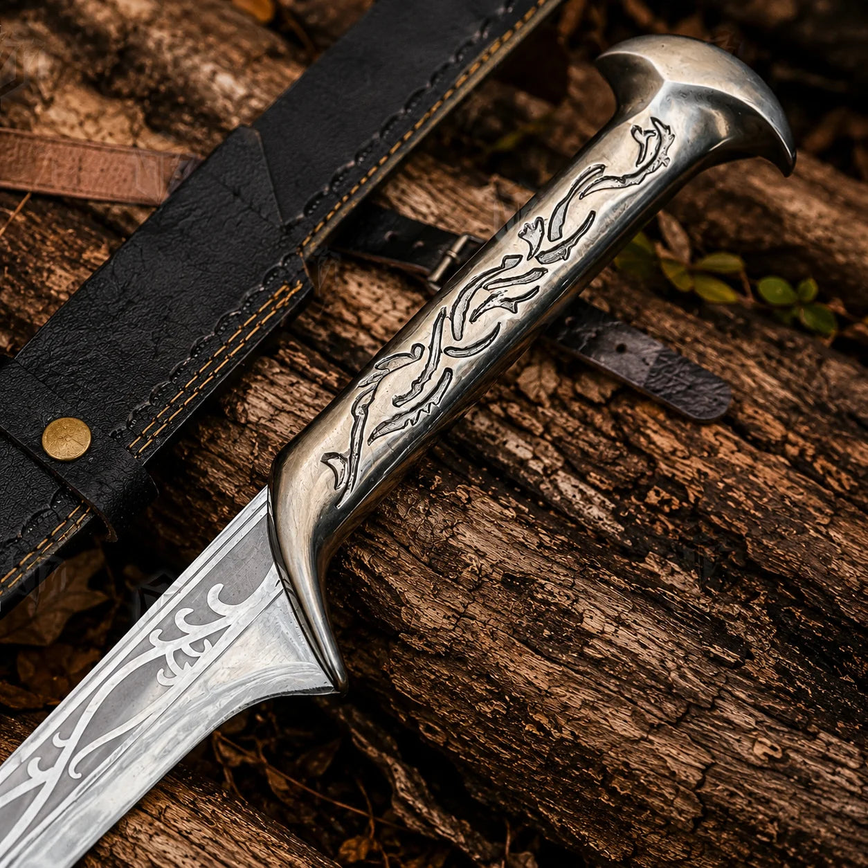 Close-up of Thranduil sword prop replica engraved elven handle and crescent-horn pommel resting on black scabbard on forest log – The Hobbit LOTR collectible