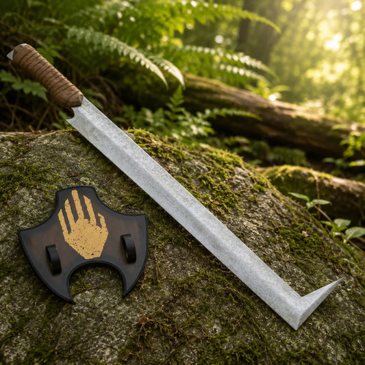 Uruk-hai scimitar prop replica full length on mossy rock in sunlit forest showing complete stone-wash crackle silver blade with distinctive L-shaped angled tip and brown leather cord-wrapped grip – LOTR Uruk-hai fan gift