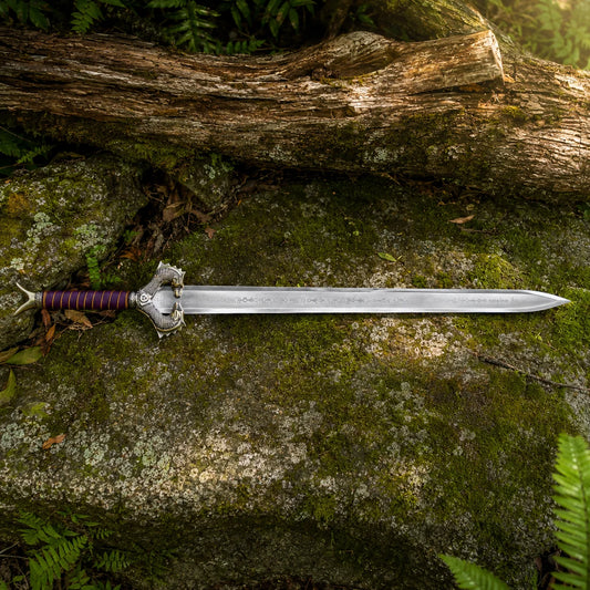 Wonder Woman God Killer Sword prop replica full view on mossy rock – DC display collectible